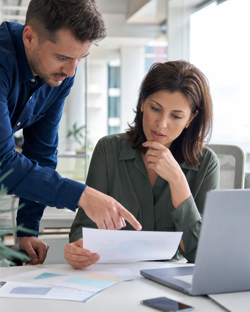 Engineering manager reviewing a vendor quote with a colleague in a startup office
