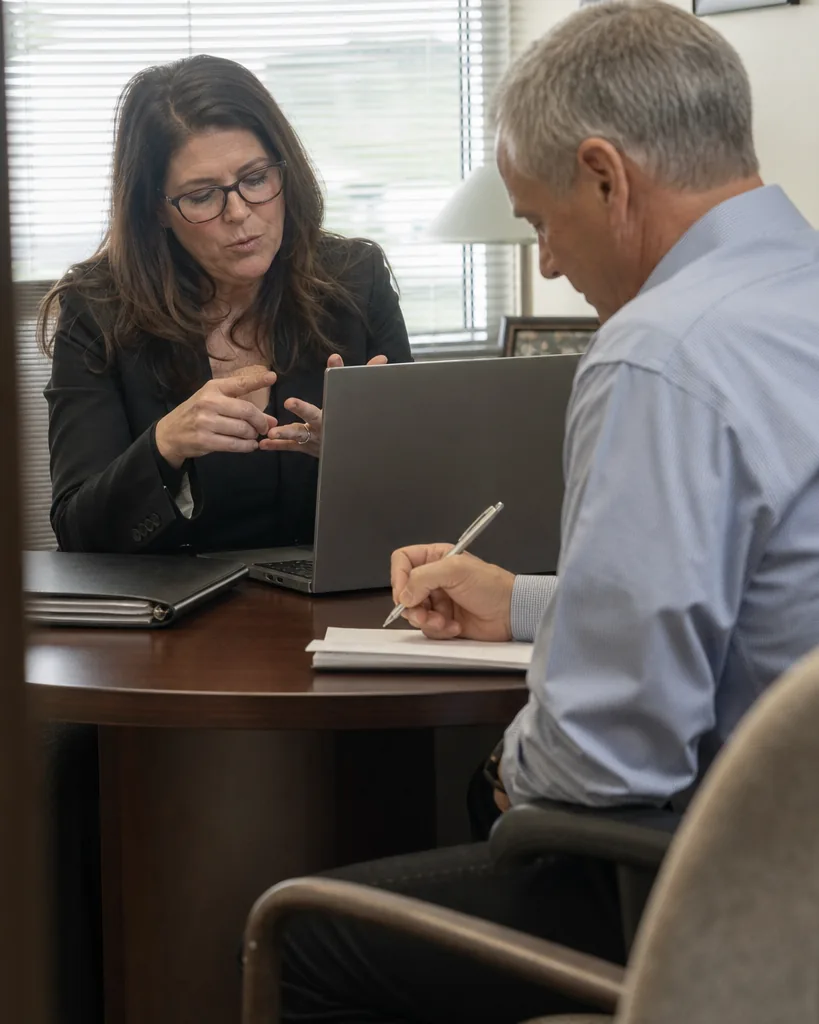 Operations lead and a finance colleague going over an on-call software renewal at a meeting table